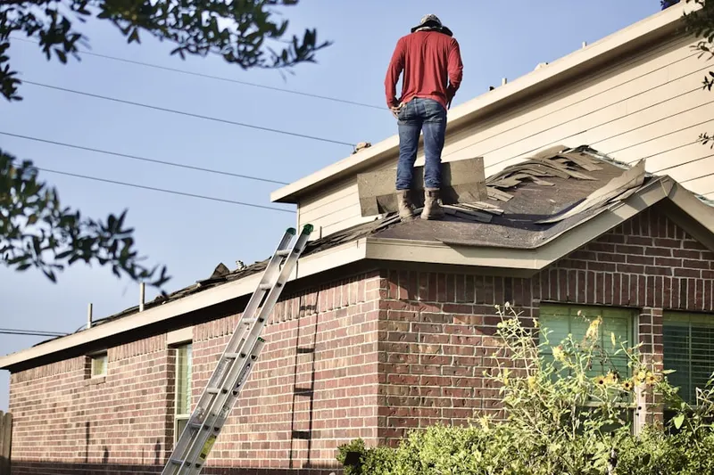 Professional roofer working on a residential roof in Primos
